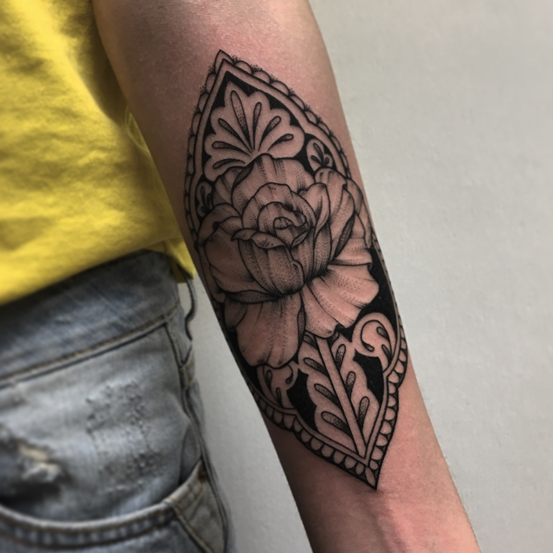 intricate floral blackwork tattoo on forearm
